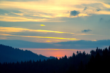 Vibrant sunset over tranquil forest landscape reflects natural beauty and serenity