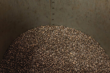 Freshly roasted coffee beans cooling in industrial drum