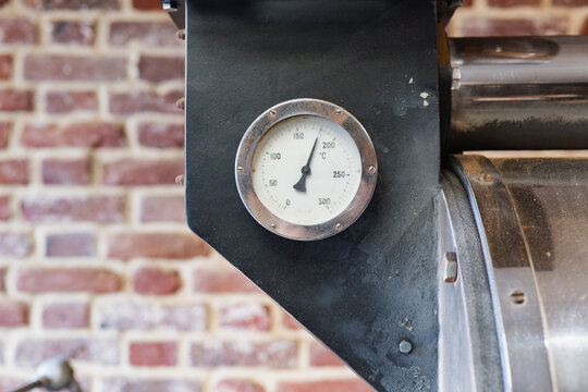 Industrial coffee roaster with temperature gauge in shop