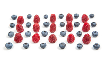 Fresh raspberries and blueberries arranged in a vibrant display on a white surface