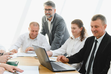 Fototapeta premium Business team analyzing data on laptop during corporate meeting
