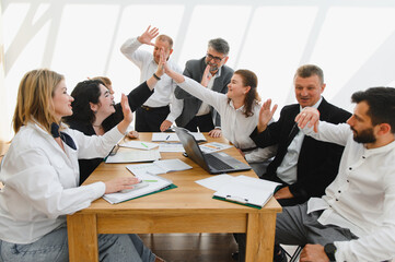 Business team celebrating success during meeting with high five