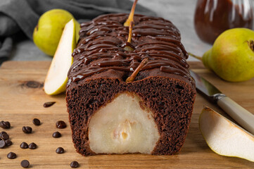 Chocolate pie or cake with whole pears and chocolate glaze on top on gray background.