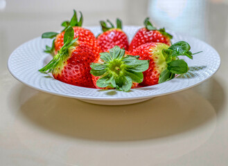 SIDE VIEW OF A PLATE WITH LARGE STRAWBERRIES FROM HUELVA SPAIN