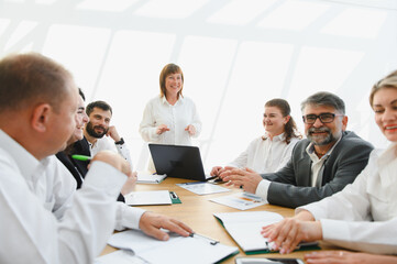 Business team meeting with senior female leader discussing strategy for success