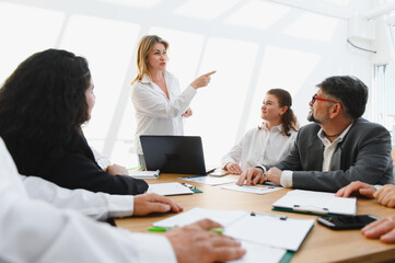 Obraz premium Business team meeting, leader explaining strategy and pointing towards success