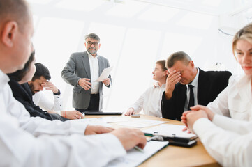 Senior manager giving bad news to business team during office meeting