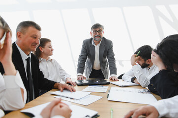 Senior businessman leading a meeting with a discouraged team