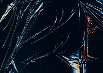 Creased plastic. Glued background. Folded distressed foil cellophane. Color scratch line flash on black abstract blur sheet screen.