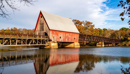 Obraz premium Rustic red barn reflects on tranquil river