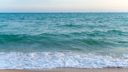 Peaceful Ocean Waves Crashing Gently on the Shore at Sunset.