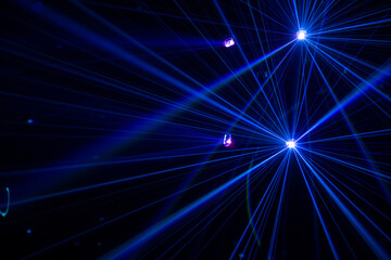 Blue laser beams in dark background.