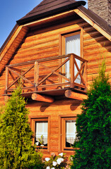 Nowoczesne drewniane domy całoroczne z bali, pod klucz.Widok na drzwi frontowe , okna i balkon (wszystko z drewna). © Pol Badger