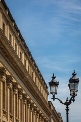 The elegant Stone Facade of the Grand Theatre Building in Bordeaux, France; Close-up with ancient Street Light and blue Sky - Copy Space