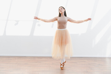 Ballerina performing graceful dance in ballet studio with natural light