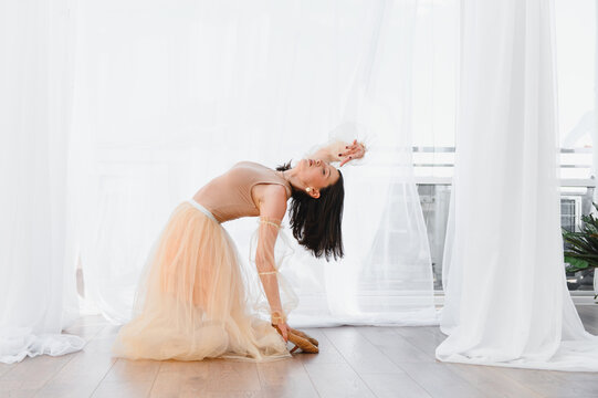 Ballerina performing a backbend in dance studio with pointe shoes - Powered by Adobe