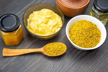 Exploring natural health benefits of bee pollen, royal jelly, and honey on a wooden table