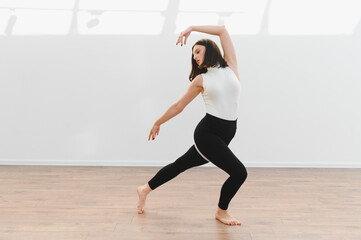 Obraz premium Young talented woman dancing modern choreography in dance school studio