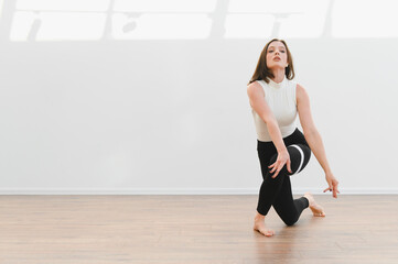 Young talented woman dancing modern choreography in dance school studio