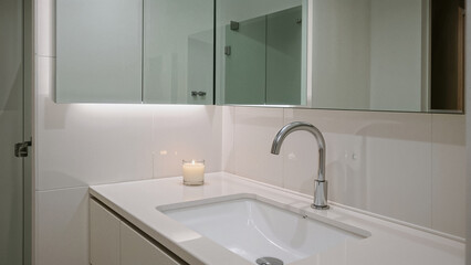 Fototapeta premium White vanity sink chrome faucet illuminated cabinet mirror image