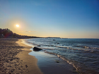 Sunset on the beach with peaceful waves and clear sky, view along the coast near the North Perd in 18586 Göhren, island of Rügen, Germany