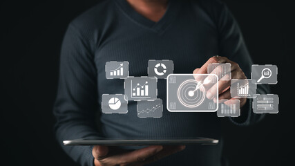person uses a digital tablet to interact with transparent analytics icons including charts, graphs, and AI, data visualization, business intelligence, and technology driven decision making.
