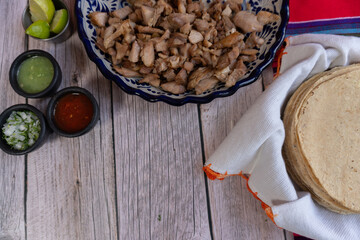 Top view with ingredients for making Carnitas tacos, tortillas, pork, and salsas, Mexican food