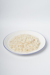Cooked white rice in a plate, plan white rice in a white plate isolated on the white background shot in a soft studio lights