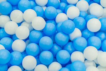Colorful blue and white balls scattered on a play area floor, perfect for children's activities and fun playtime moments
