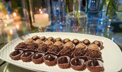 Luscious chocolate desserts in a table and a candle behind.