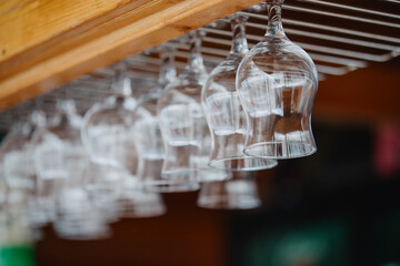 Glasses hanging upside down above the bar counter. Clean transparent glasses