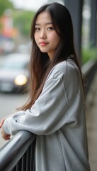 Thoughtful young woman leaning on a railing
