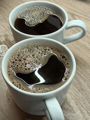 Two Mugs of Freshly Brewed Black Coffee with Foam