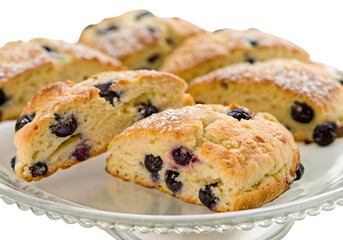 Freshly baked blueberry scones on plate with sugar topping displayed in close up with golden crust