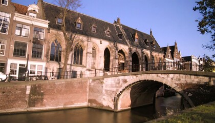 Naklejka premium Dutch canal scene with historic buildings and bridge