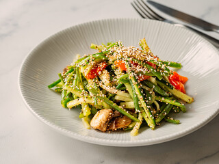Delicious pork meat salad with cucumber in asian style with amaranth popcorn or popped amaranth (replaceable sesame). Idea salad recipe for healthy food menu. Vibrant bright pork salad with cucumber