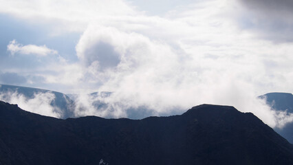 Mountain peaks in the clouds. A chain of gray mountains in the backlight. Khibiny