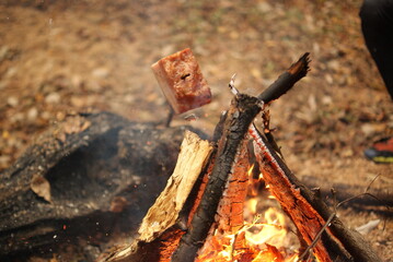 焚火の火柱とベーコンクローズアップ