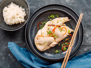 Sous Vide Chicken with spices. Boiled chicken sous-vide on black plate served with boiled rice. Sous-vide is culinary method of long-term cooking. Top view.