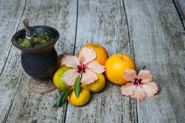 Variety of fruits including , oranges, grapefruits and hibiscus flowers ,  and mate on the table