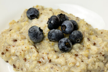 A bowl of oatmeal topped with fresh blueberries. 