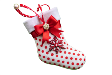 Festive christmas stocking ornament isolated on transparent background, adorned with red polka dots, a bow, and a snowflake for holiday cheer
