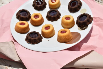 chocolate cupcakes and cupcakes with jam on white plate top view 