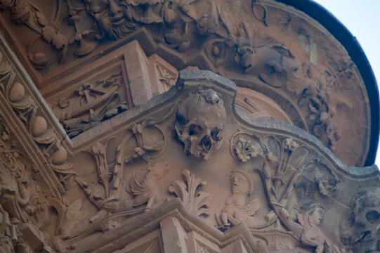 Famous carved stone skull and frog on historic plateresque facade of the University of Salamanca in Spain