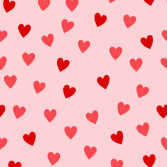 Pattern of red and pink hearts on a light pink background  