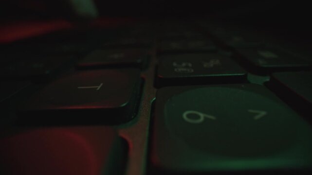 Macro View of Finger Pressing Delete Key on Illuminated Keyboard