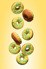 Yellow glazed donuts, each decorated with multi colored sprinkles.