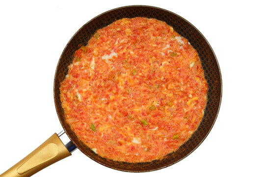Turkish traditional menemen dish made with eggs, onions, peppers and tomatoes on white background