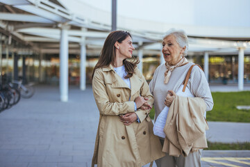 Fototapeta premium Smiling Women Enjoying a Conversation While Shopping Outdoors Together