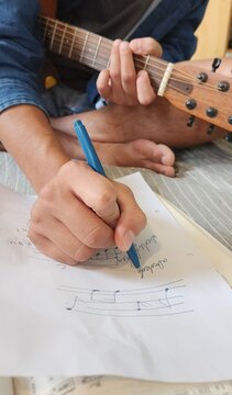 Writing Music Notes with Guitar in Hand